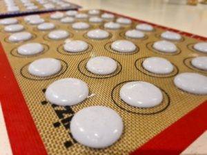 Macarons piped onto a baking tray